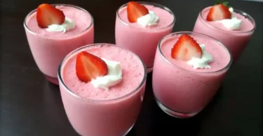 Overhead view of ingredients for a Greek Yogurt Jello Recipe, including Jell-O mix, boiling water, and creamy Greek yogurt on a white countertop.