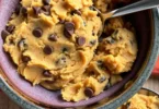Overhead view of protein cookie dough recipe ingredients including almond flour, protein powder, and chocolate chips on a marble counter
