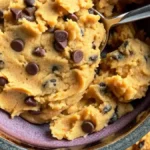 Overhead view of protein cookie dough recipe ingredients including almond flour, protein powder, and chocolate chips on a marble counter